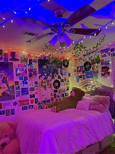 a bed room with a neatly made bed and lots of pictures on the wall above it