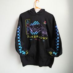 a black hoodie with an image of a video game controller on it hanging from a hanger