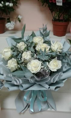 a bouquet of white roses sitting on top of a table