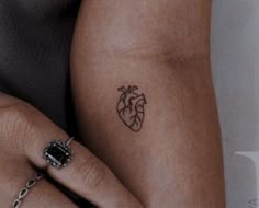 a woman's arm with a heart tattoo on the left side of her body