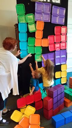 two children are playing with blocks on the wall