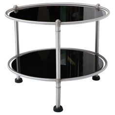 a glass and metal table with wheels on the bottom, one shelf has two shelves