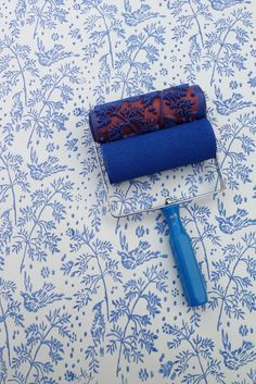 a roll of blue fabric sitting on top of a metal holder next to a roller