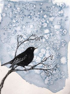 a black bird sitting on top of a tree branch with snow flakes in the background