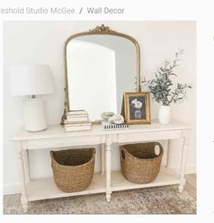 a white table with two baskets and a mirror