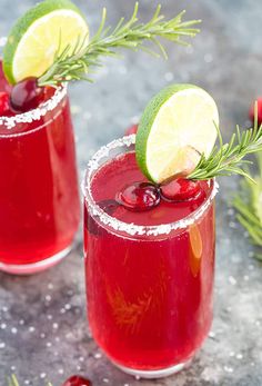 two glasses filled with cranberry margaritas and garnished with fresh rosemary