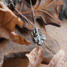 "Hand sculpted fine silver oak leaf pendant. A botanical talisman symbolic of reverence for nature ~ complete with its very own little halo. A wearable idol for every day! The oak is regarded across the world as a symbol of wisdom, strength and endurance. Available on its own or strung from your choice of elegant sterling silver chain or leather cord for a more casual look. This pendant represents a substantial amount of solid fine silver (.999 / 99.9% pure silver) and has a lovely weight and fe Nature-inspired Silver Jewelry With Charms, Nature-inspired Engraved Sterling Silver Necklace, Nature-inspired Pendant Jewelry With Charms, Nature-inspired Carved Sterling Silver Jewelry, Nature-inspired Pendant Charms Jewelry, Nature-inspired Hand-cast Pendant Jewelry, Nature-inspired Hand Cast Pendant Jewelry, Nature-inspired Leaf Shape Sterling Silver Jewelry, Hand Cast Nature-inspired Sterling Silver Jewelry