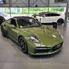 a green porsche sports car in a showroom