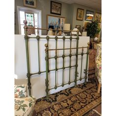 a green metal bed frame sitting on top of a rug