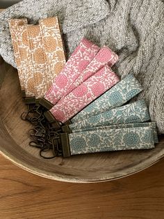 a wooden bowl filled with lots of different colored napkins on top of a table