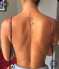 the back of a woman's body with tattoos on her upper and lower back