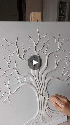 someone is painting a tree with white paint