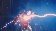 a man dressed as iron man with lightning in his hands