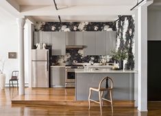 the kitchen is decorated in black and white floral wallpaper