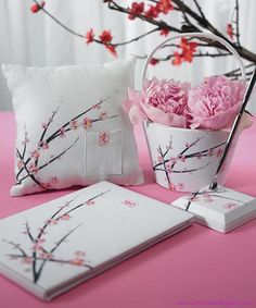 pink flowers are in a vase next to two pillows