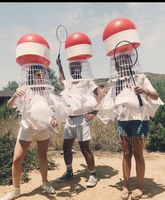 three people with tennis rackets in front of their faces, one holding a tennis racquet