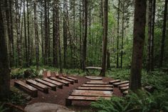 several wooden benches in the middle of a forest