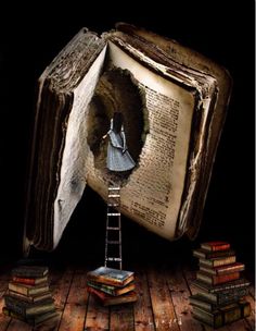 an open book sitting on top of a wooden floor with a ladder going into it