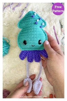 a crocheted octopus hat is being held up by someone's hand with scissors