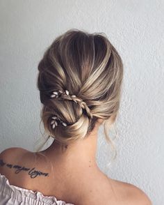 the back of a woman's head with her hair in a low bun and braid