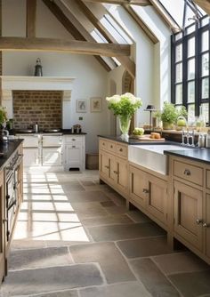 a kitchen filled with lots of wooden cabinets and counter top space next to a window