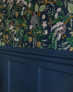 the wallpaper in this room is painted with blue and green flowers, leaves and berries