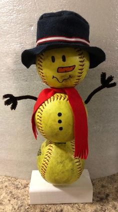 a yellow baseball with a black hat and red scarf