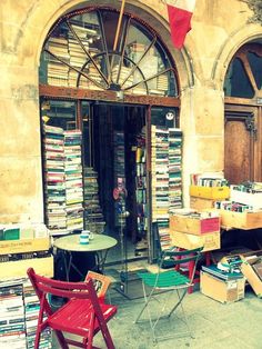 an outdoor book store with tables and chairs outside the front door, full of books