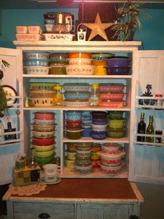 a cabinet filled with lots of bowls and dishes on top of it's shelves