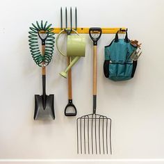 gardening utensils hanging on a white wall