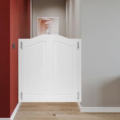 an open white door in a room with red walls and hardwood floors, leading to a hallway