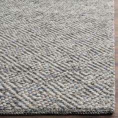 a gray rug on top of a wooden floor