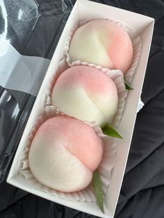 three pink and white desserts in a box