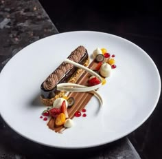 a white plate topped with a piece of chocolate cake