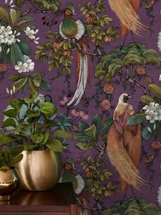 the wallpaper is very colorful and has birds on it, while flowers are in gold vases