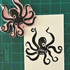 an octopus is sitting on top of a piece of paper next to a stamp that has been cut out