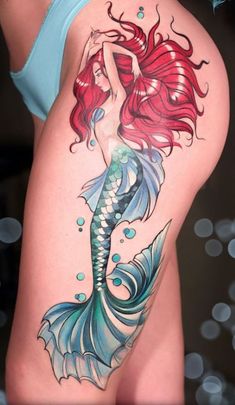 a woman's thigh with a tattoo of a mermaid on it