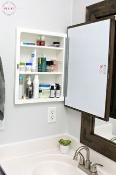 a bathroom sink with medicine bottles on the shelf above it and a towel hanging from the wall