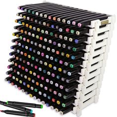 a large stack of pens and markers sitting next to each other on a white surface