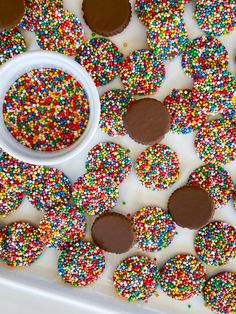 chocolate covered donuts and sprinkles on a tray