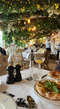 the table is set with pizza and wine glasses on it, along with other food items