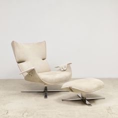 an egg chair and footstool in white leather