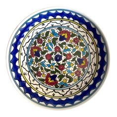 a blue and white plate with flowers painted on the side, sitting in front of a white background