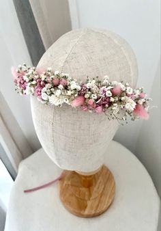 a white mannequin with pink and white flowers on it's headpiece