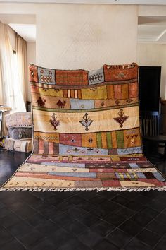 a large multicolored rug sitting on top of a black tile floor