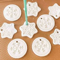 snowflake ornament ornaments are hanging from a green string on a table