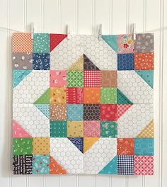 a colorful quilt hanging on a wall