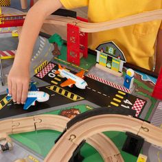 a young boy playing with his toy train set