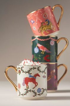 three mugs are stacked on top of each other, one has a horse painted on it