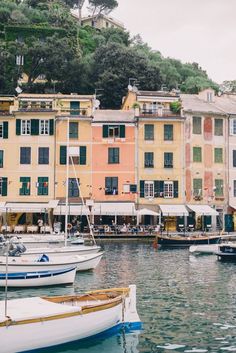 several boats are docked in the water near buildings